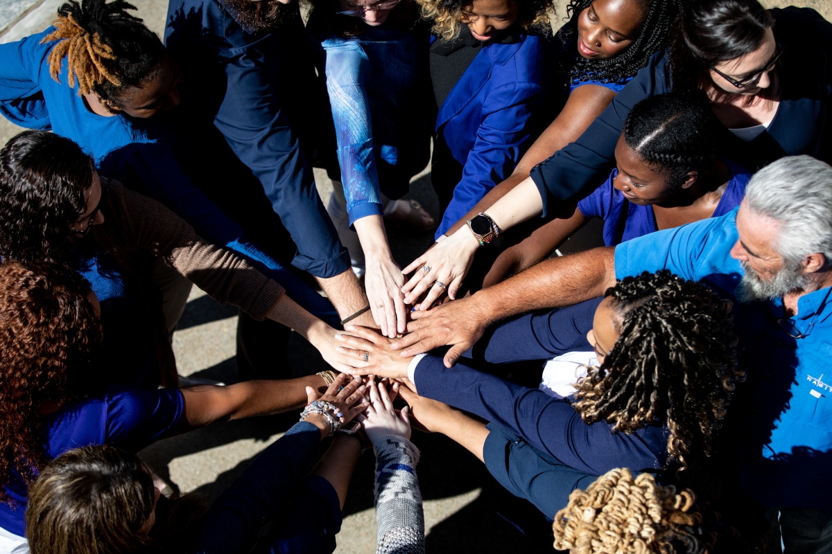 team holding hands together